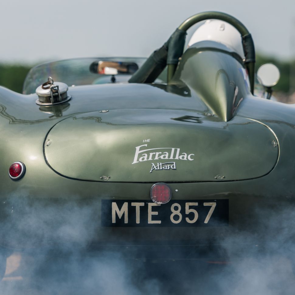 A classic sports car from behind with smoke and Bicester Motion